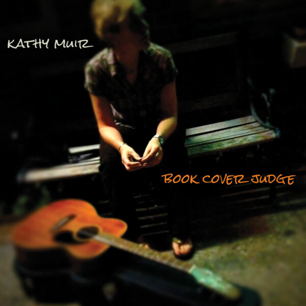 Women sitting on a bench with her guitar on the ground